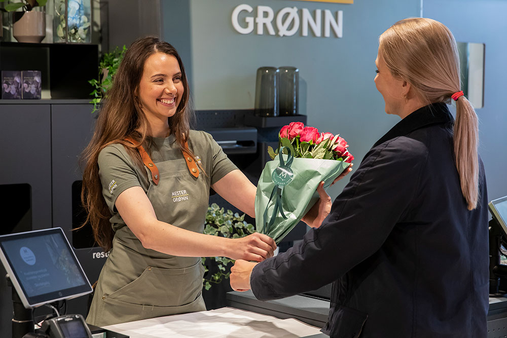 Kvinne handler blomster i blomsterbutikk